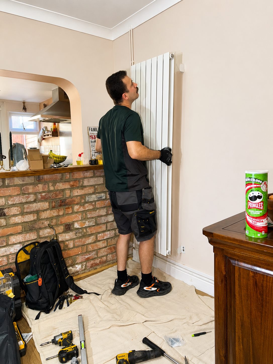 Radiator installation work with visible pipework and tools
