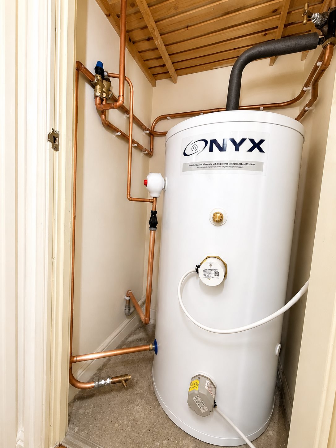 Hot water cylinder cupboard with neat copper pipework